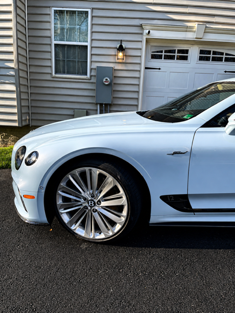 White Bentley Continental GT Speed with polished paint and bright wheels in a driveway