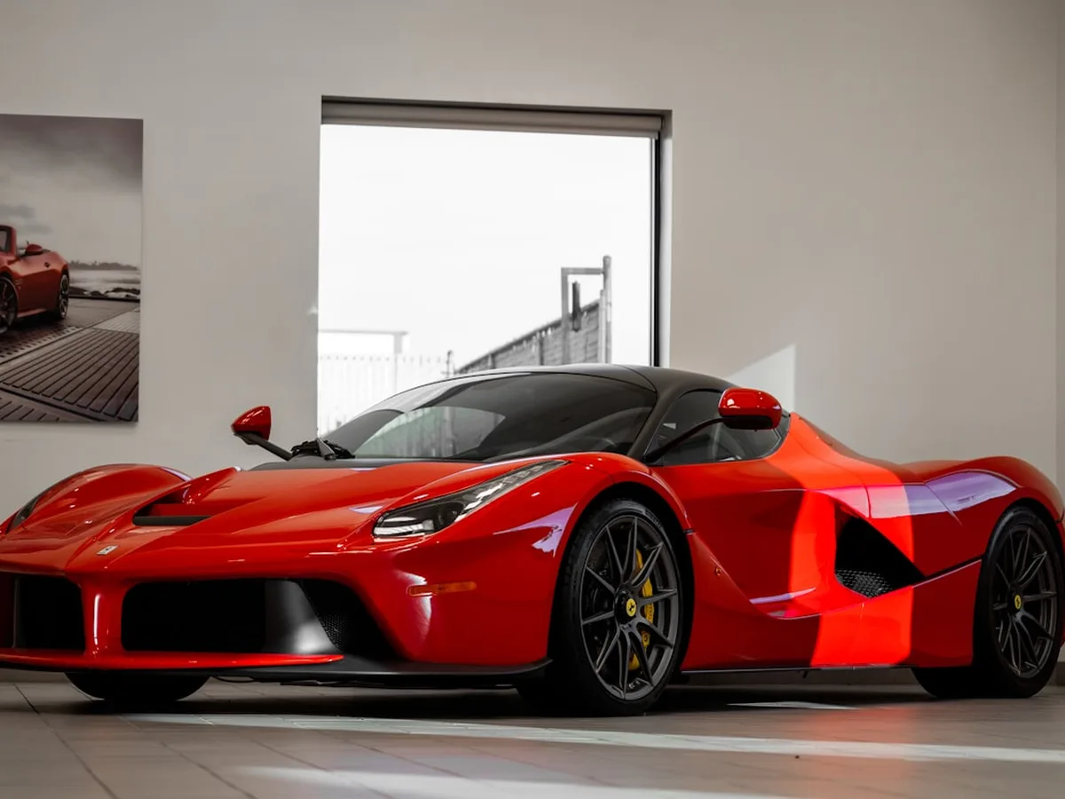 Red supercar under indoor lighting showing sharp reflections on coated paint